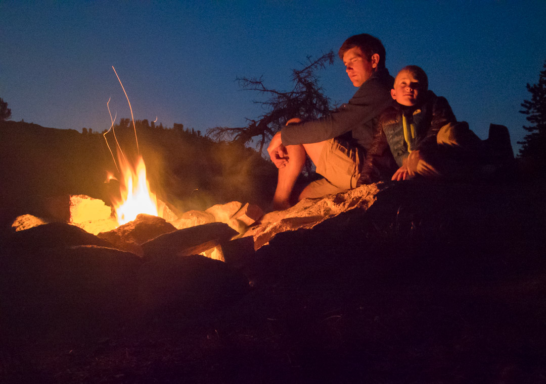 father and son by a campfire